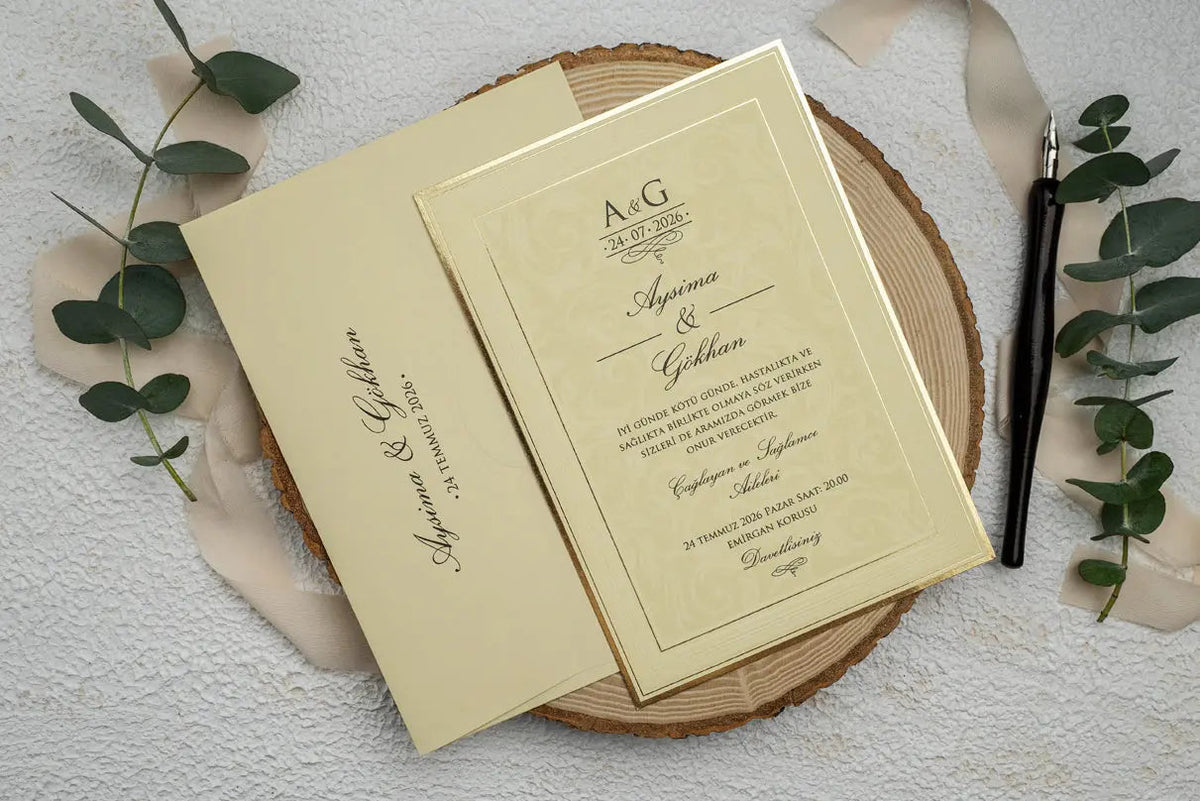 Angled cream wedding invitation and matching envelope, with a gold border around the invitation wording.