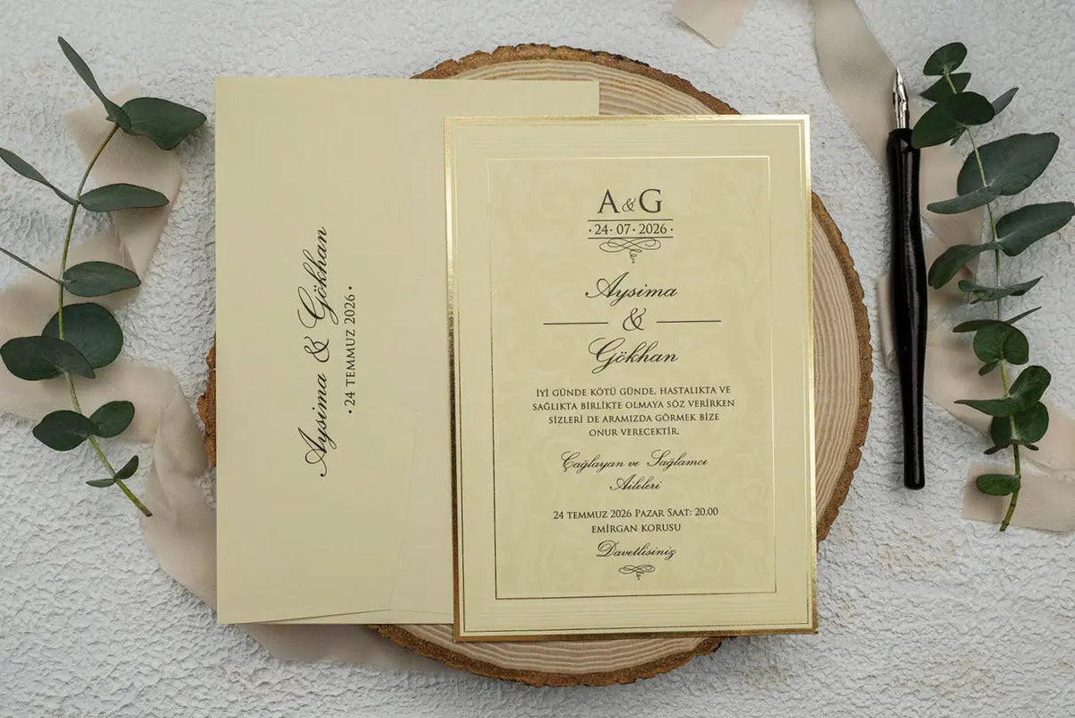 Cream paper wedding invitation with a gold border beside its matching envelope.