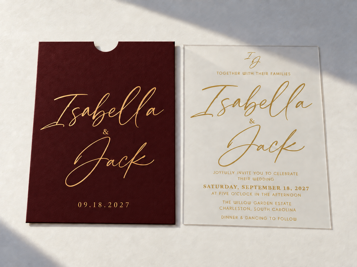 Signature Script invitation with a burgundy pocket sleeve and clear card, both featuring large gold script names.