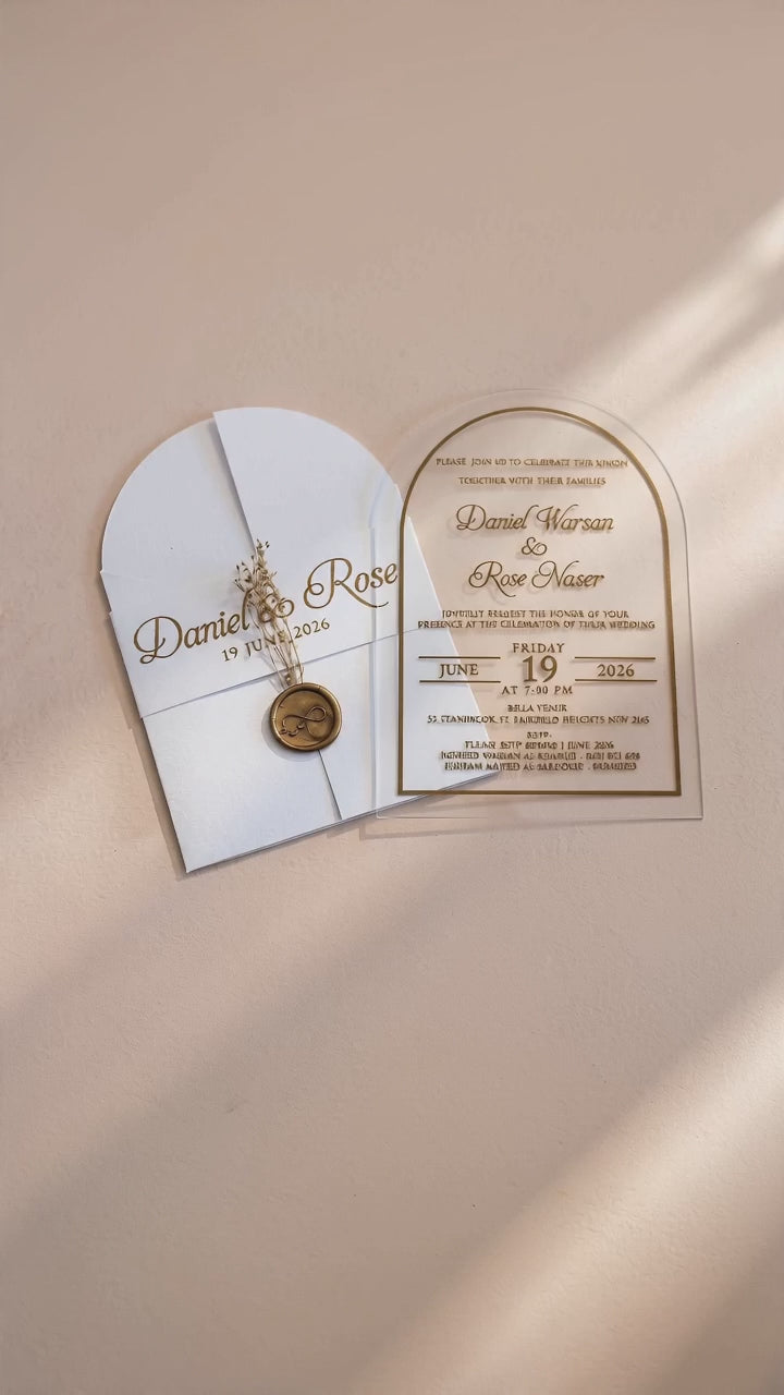 Video showing the white cover's wax seal and dried flowers, then lifting and tilting the clear arched acrylic invitation to show its transparency.