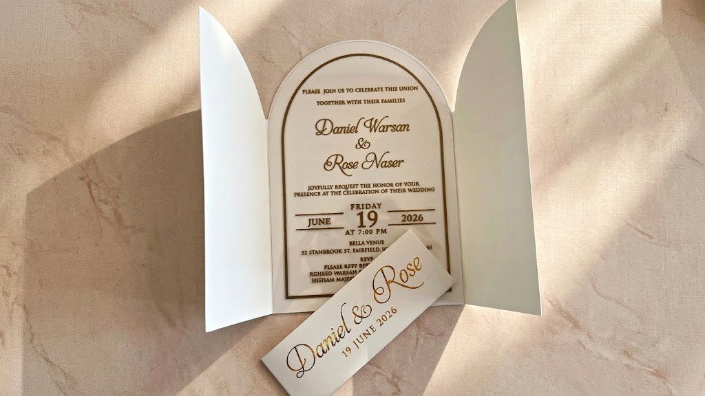 Front view of the open white gatefold cover with the arched clear acrylic invitation inside and the matching printed paper band removed in front.